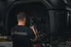 Starwood Customs employee installing upgraded suspension on a truck in thier Northwest Arkansas based off road shop.